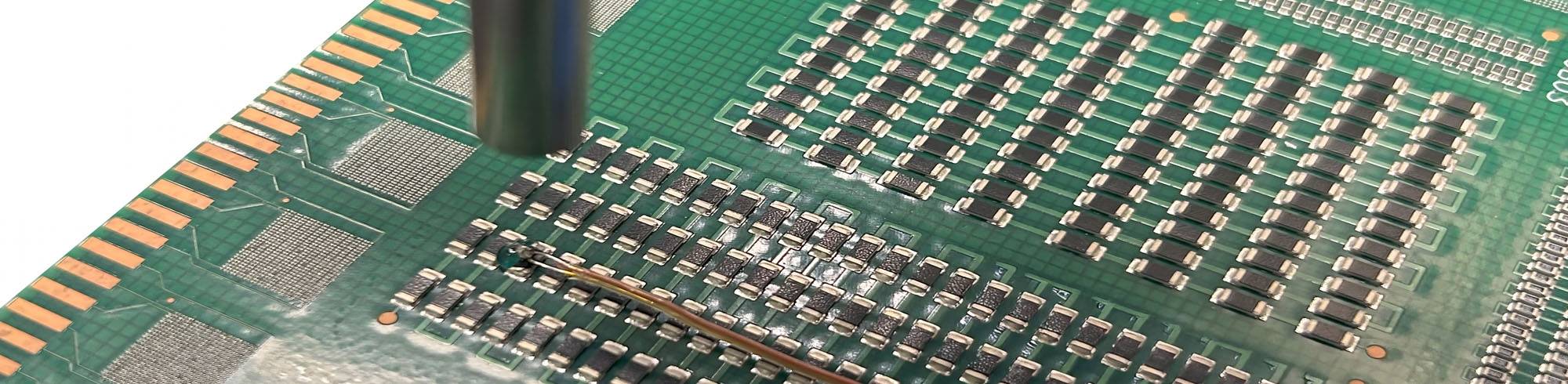 A thermocouple is bonded to a PCB with Dymax 9037-F adhesive and cured with a light-curing spot system.